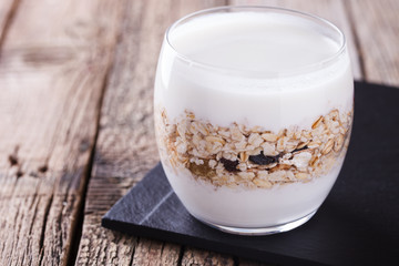 Breakfast with muesli, yogurt in a glass on a wooden background. selective focus