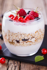 Breakfast with muesli, yogurt,honey and fresh berries in a glass on a wooden background. selective focus