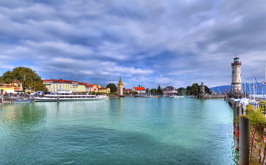 Fototapeta premium Blick auf den Hafen auf der Insel von Lindau am Bodensee im Süden Deutschlands mit dem historischen Leuchtturm.