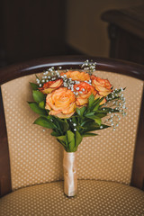A bouquet of flowers lies on a beige chair 3505.