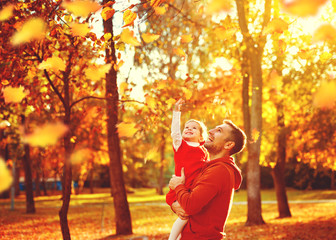 Happy family father and child daughter on a walk in autumn leaf