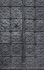 Old church iron door decorated with lilies pattern, attribute of Virgin Mary