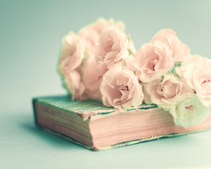 White roses over a vintage book