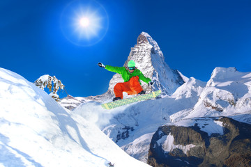 Snowboarder jumping against Matterhorn peak in Switzerland