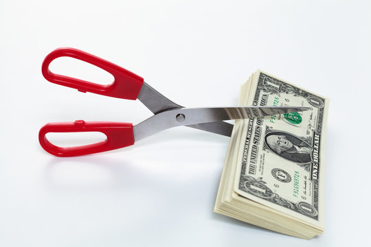 scissors cutting dollar bills