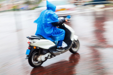 Motorrollerfahrer bei Regen in Bewegungsunschärfe