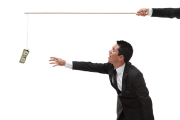 Exhausted Businessman reaching for money on the end of a stick