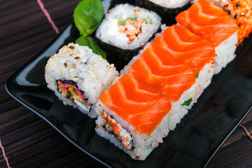  japanese food style.   sushi rolls assortment on black plate. Traditional  rolls on the dish.