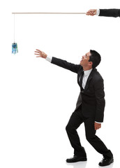 Tired businessman reaching out for euro bills on a stick