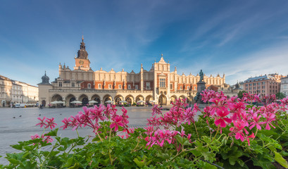 Cloth hall on the main market square in Krakow, Poland, with geranium flowers during golden hour