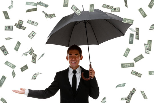 Raining money on a businessman holding an umbrella