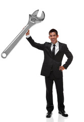 Businessman holding a gaint adjustable wrench up as a business t