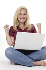 Woman Sits on Floor with Laptop and Fist Pump