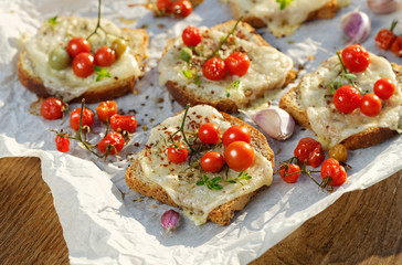 Bruschetta with cheese, cherry tomatoes and aromatic herbs