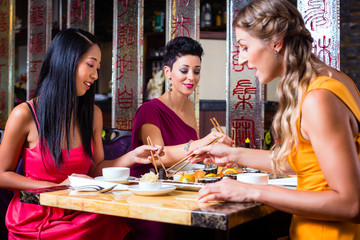 Fototapeta premium Young people eating sushi in Asian restaurant