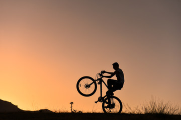 Obraz premium bisikletin önünü kaldırmak & bisikletli akrobat