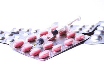 Obraz na płótnie Canvas Medicine pills or capsules with syringe