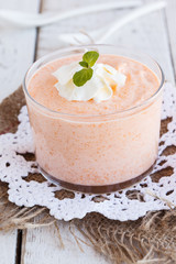 Pumpkin mousse,decorated with mint leaves and whipped cream  in a glass beaker.selective focus