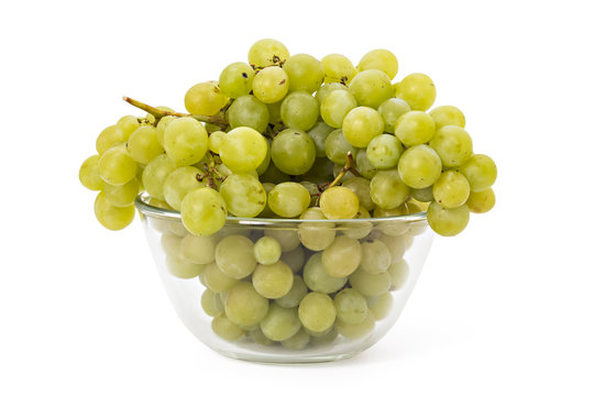 Fresh ripe white grapes clusters in a bowl on white background
