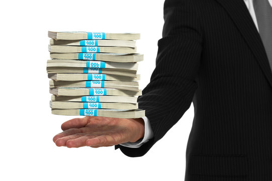 Close up of businessman hand with stacks of money floating above