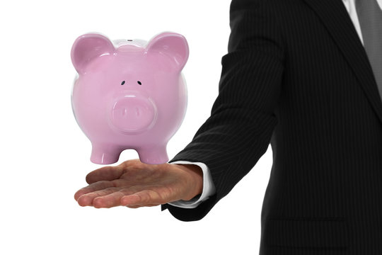 Close up of businessman hand with piggy bank floating above it