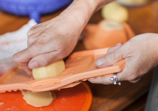 Woman hands working on a potato grater