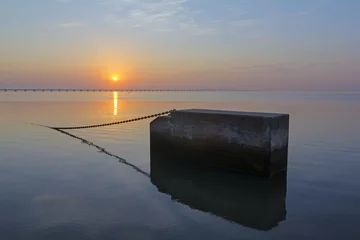 Papier Peint photo autocollant Pont Vasco da Gama Bloco de Betão no Rio Tejo ao nascer do sol