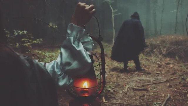 Girl with lantern and among male figure in the terrible forest