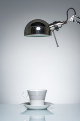 lighting up white mug coffee cup with desk lamp