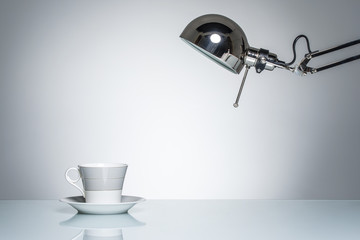lighting up white mug coffee cup with desk lamp