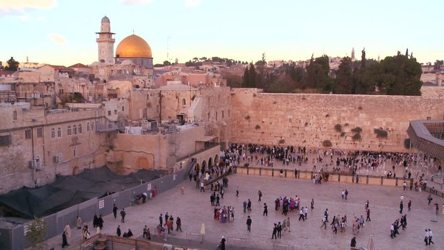 Fast motion of people beneath The Dome of the Rock as it towers over the Old City of Jerusalem and the Wailing Wall.
