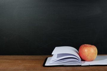 Apple and Opened Book with Blackboard Background