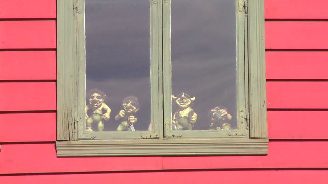 Small troll dolls sit in a window in Norway.