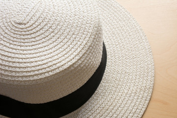 Fototapeta na wymiar Beautiful white beach hat on wood floor
