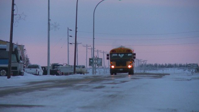 A school bus travels along an icy snowy road at Churchill, Manitoba, Canada, Hudson Bay.