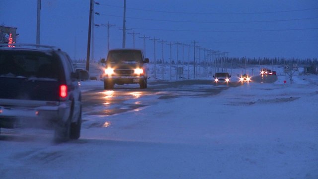 Vehicles travel along an icy snowy road at Churchill, Manitoba, Canada, Hudson Bay.