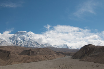 Empty riverbed with snow mountain and blue sky on a sunny day