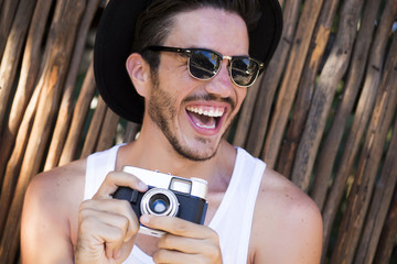 Hipster young man with vintage camera outdoors
