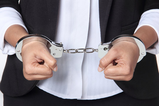 Corporate fraud concept - business executive in hand cuffs