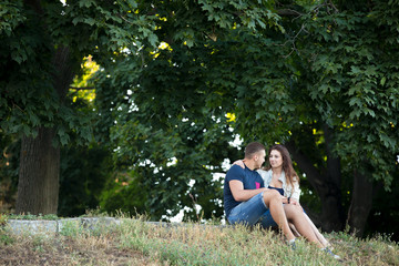Naklejka na ściany i meble Couple in love resting under the trees