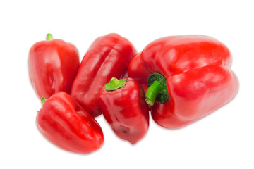 Several red bell peppers different sizes on a light background