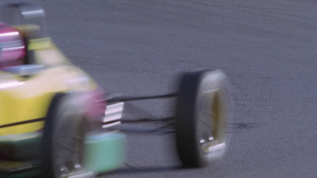 A race car heads into a turn on a race track.