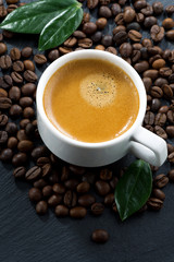 cup of fresh espresso on coffee beans background, top view