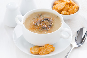 delicious mushroom cream soup with croutons on white table