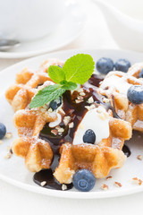 waffles with fresh blueberries for breakfast, close-up, vertical
