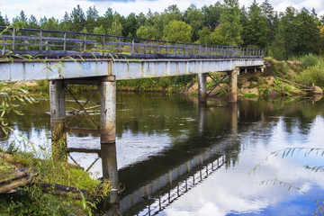 landscape background old rusty iron bridge over a river forest with trees along the banks
