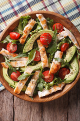 Chicken salad with avocado, arugula and tomatoes closeup. vertical top view

