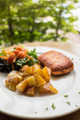 salmon steak with roast potato and salad