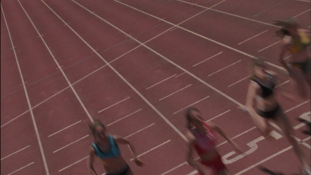 Five women run a race on a racetrack.