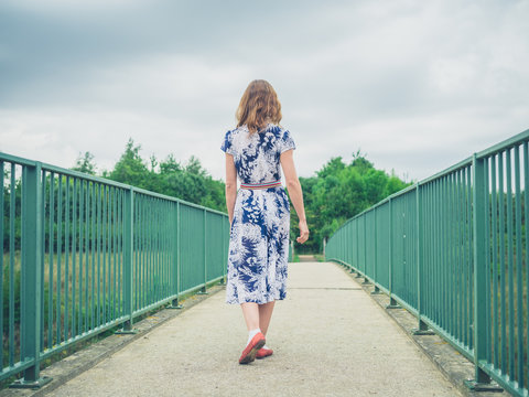 Woman walking on footbridge in country